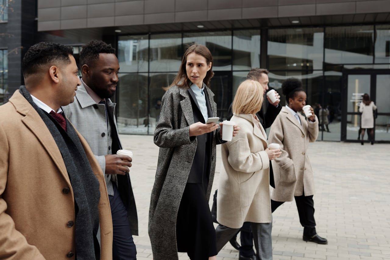 A group of diverse business professionals enjoying a coffee break outdoors in the city.