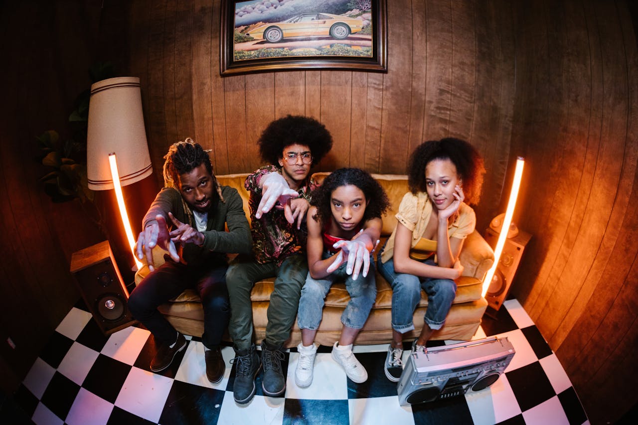 Four young friends hanging out on a vintage couch.